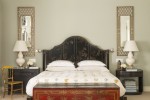 Master bedroom with large bed with leather textured headboard. Matching side tables, with lamps.